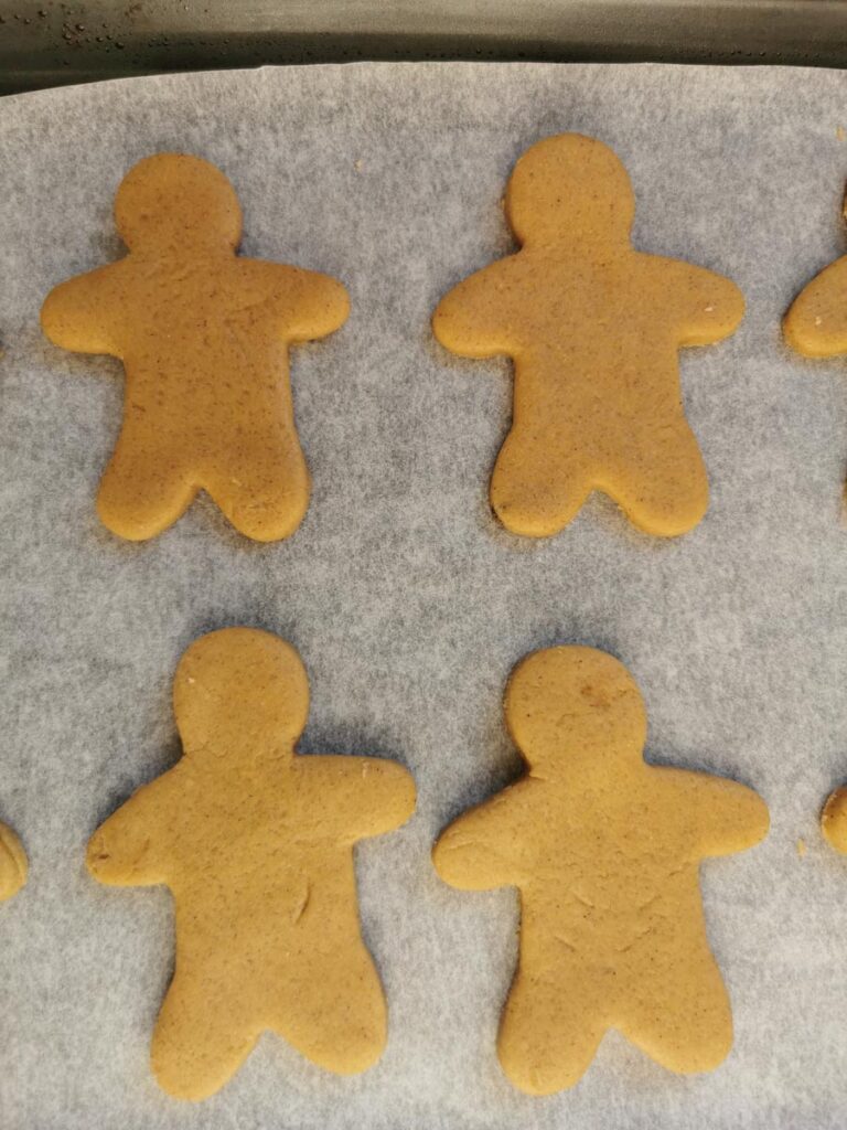 Unbaked gingerbread people on a baking tray.
