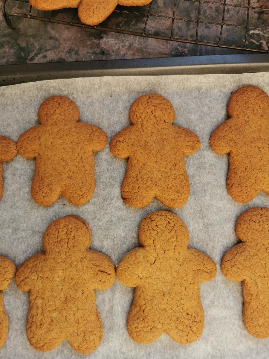 Freshly baked gingerbread men on a baking tray.