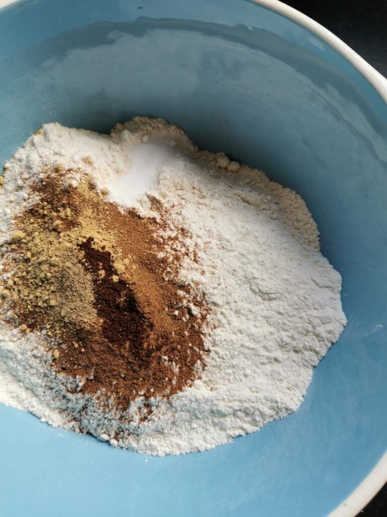A blue and white bowl of flour and ground spices.