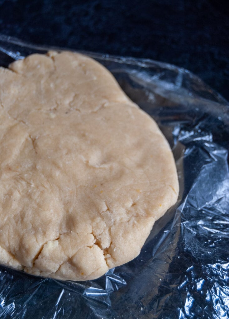 a piece of shortbread dough sitting on a piece of cling film.