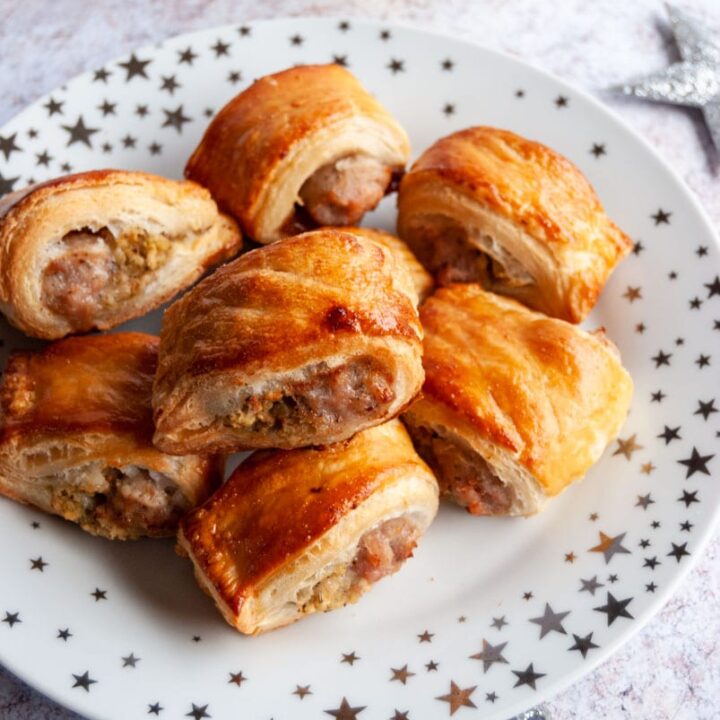 a white and silver star plate of puff pastry sausage rolls.