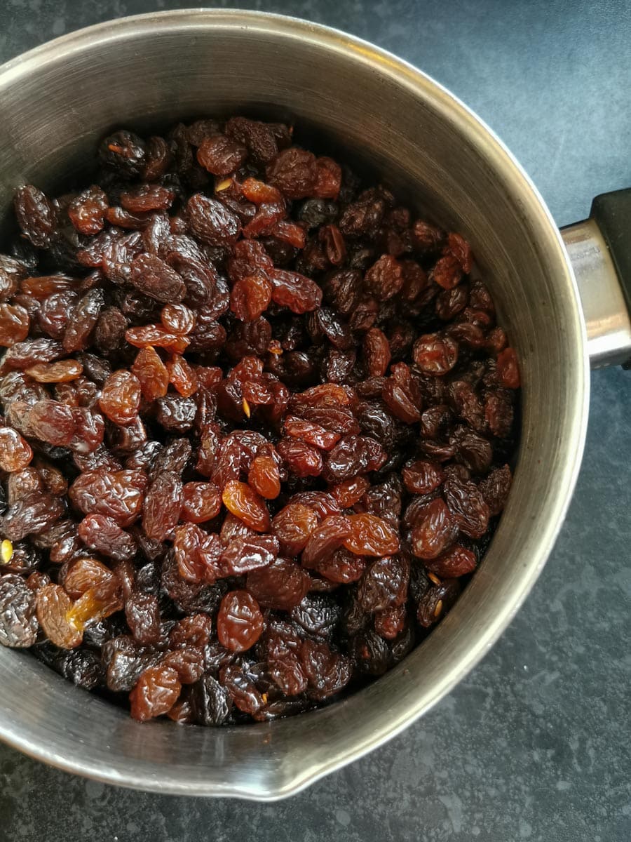 sultanas and raisins in a silver saucepan.