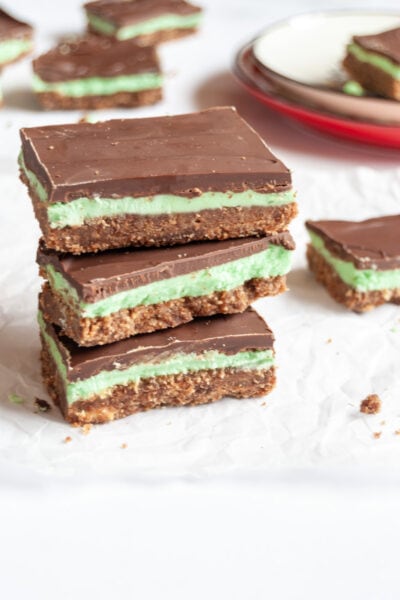 three squares of mint slice stacked on top of each other on a piece of baking paper.