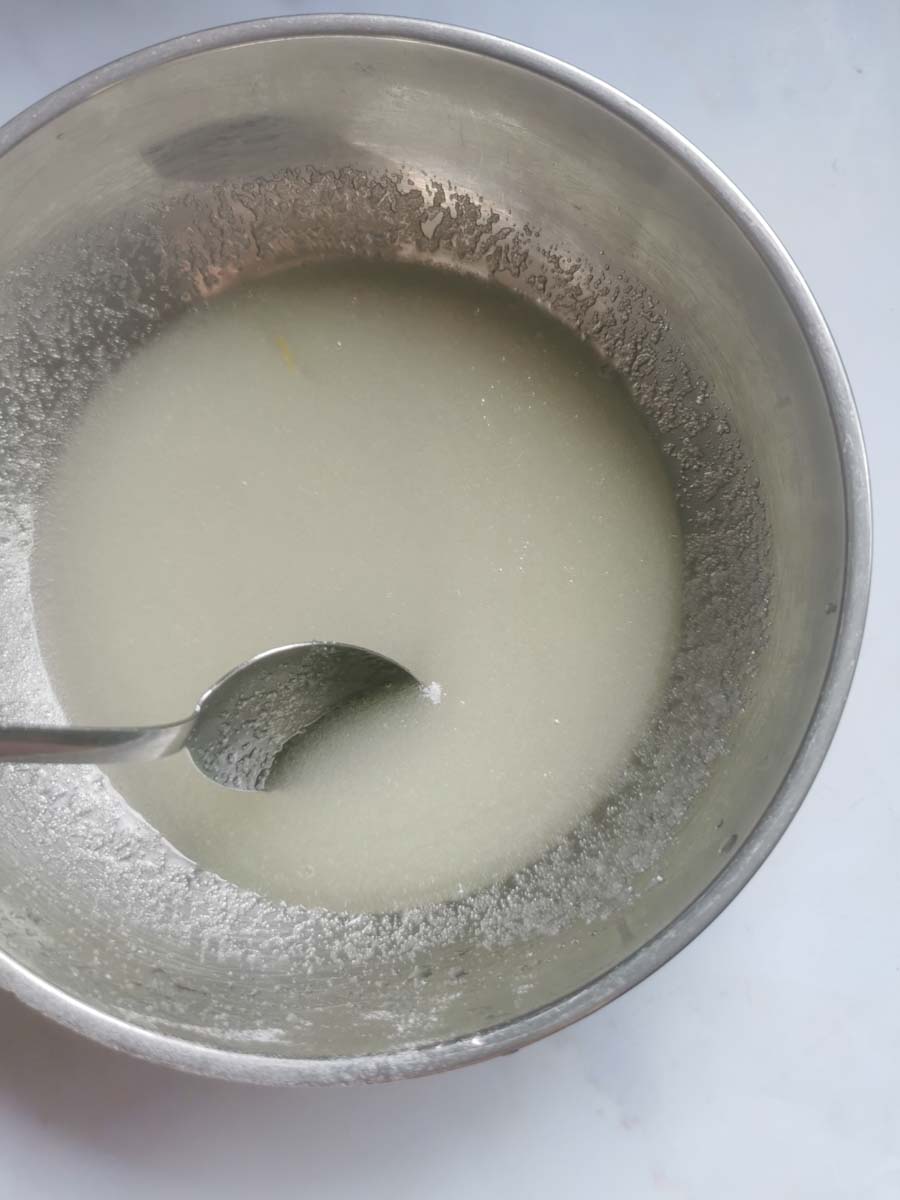 a silver bowl of lemon juice and sugar with a silver spoon.