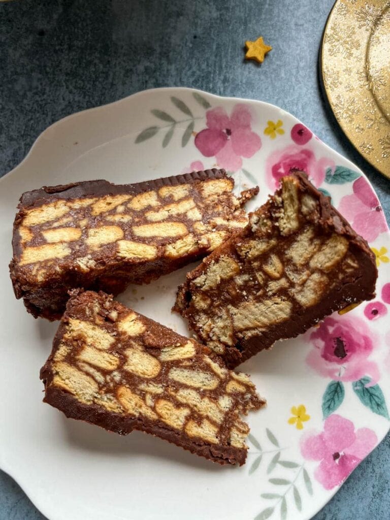 three pieces of chocolate biscuit cake on a floral plate,