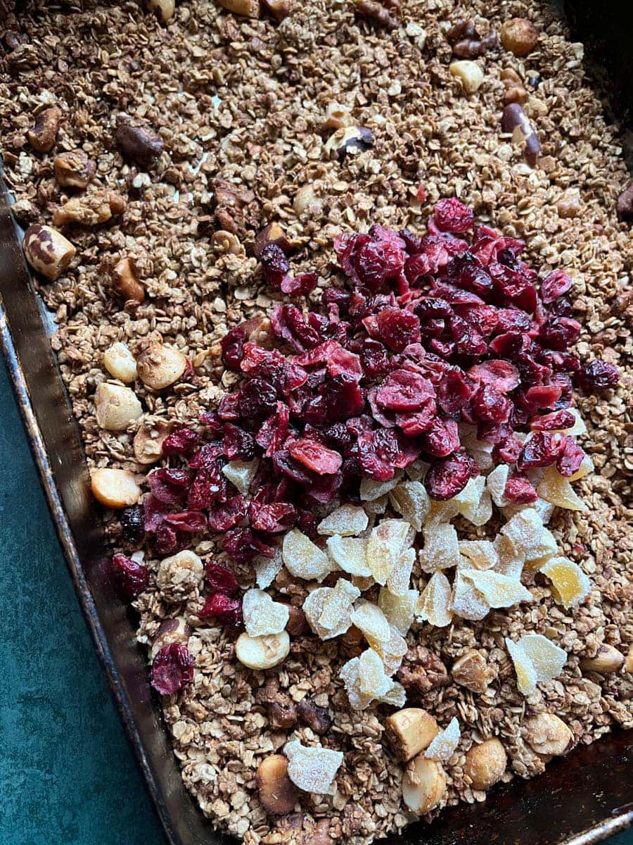 a large tray of granola with dried cranberries, chopped candied ginger and mixed nuts.