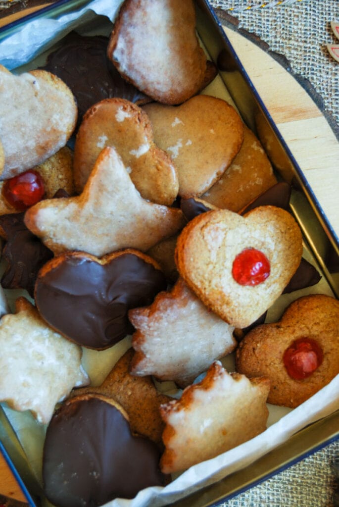 a box filled with German gingerbread biscuits in the shape of hearts and stars, glazed with chocolate, icing and glace cherries.