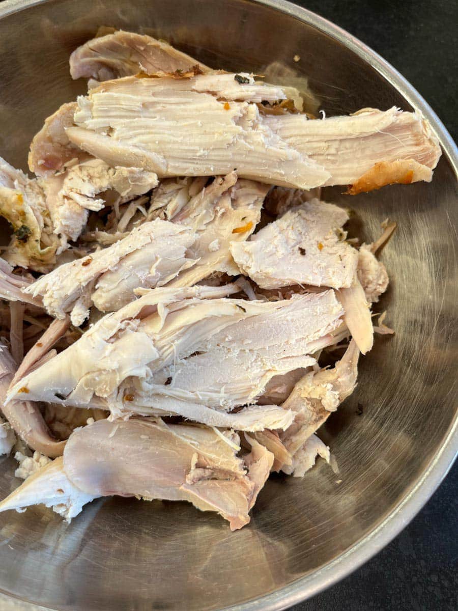 a silver bowl of cooked cold turkey.
