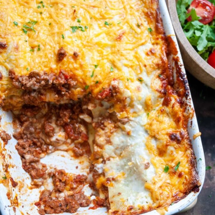 a large lasagne topped with cheese in a white dish.