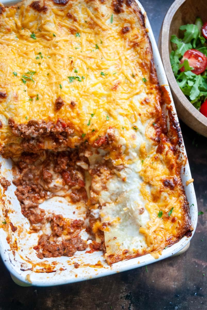 a large lasagne topped with cheese in a white dish.