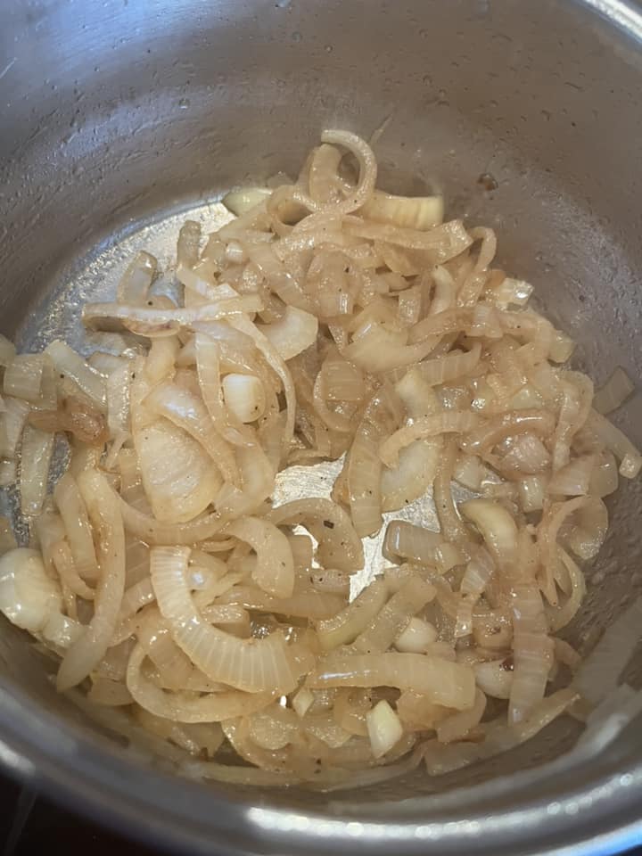 a silver pan of sliced cooked onions.