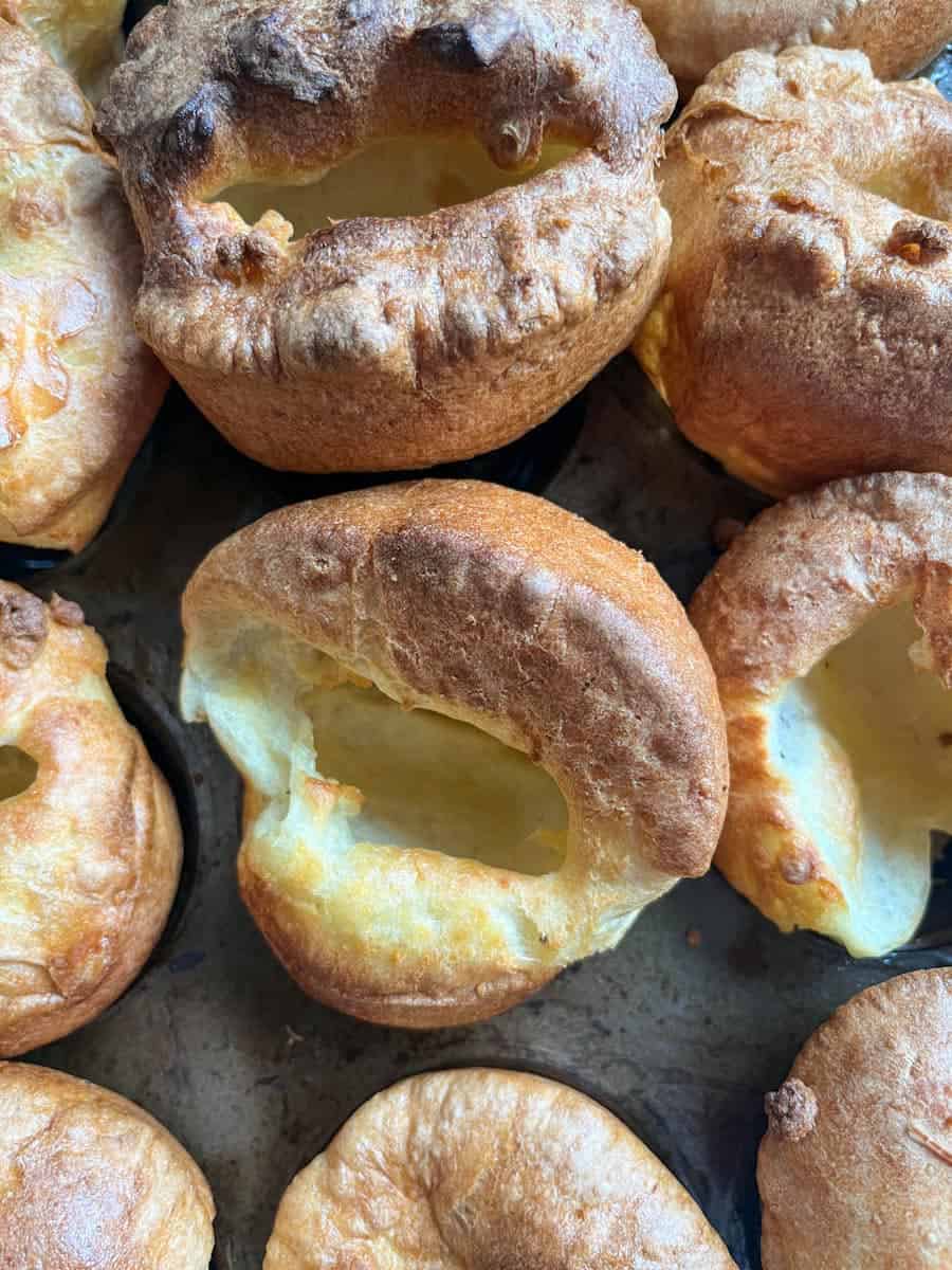 a metal baking tin of nine golden, well risen Yorkshire puddings.