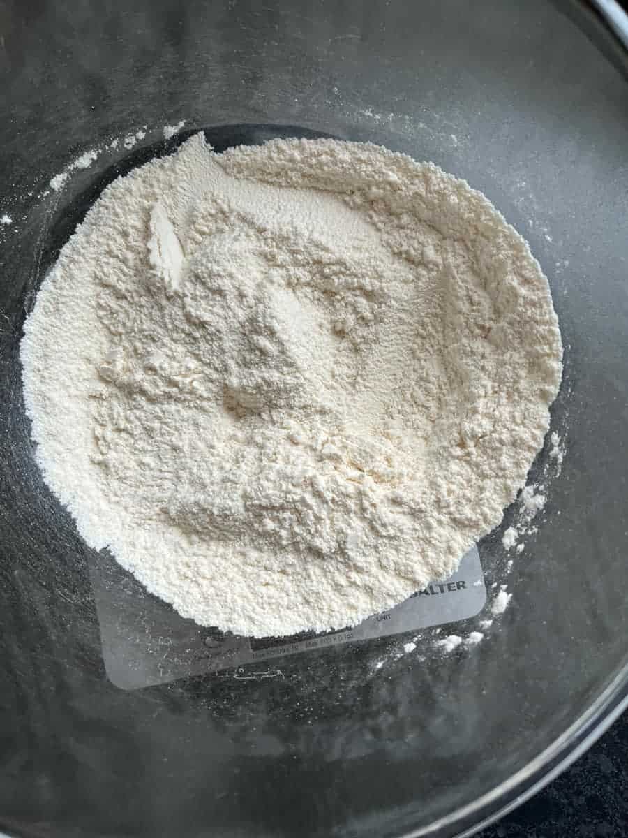 a large glass mixing bowl of flour.