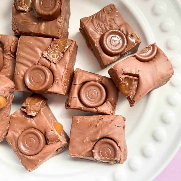 a white plate of chocolate fudge with Rolo sweets.