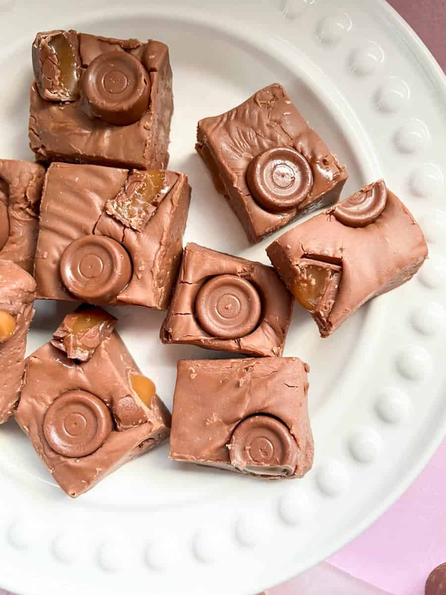 a white plate of chocolate fudge with Rolo sweets.