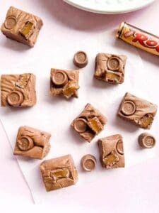 Nine pieces of Rolo Fudge on a piece of baking parchment and a packet of Rolos.