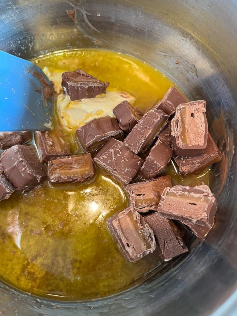 chopped mars bars, butter and golden syrup melting in a saucepan.