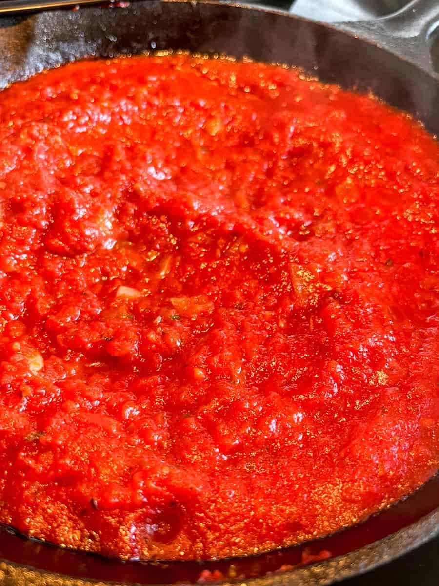 a black saucepan of cooked tomato sauce.