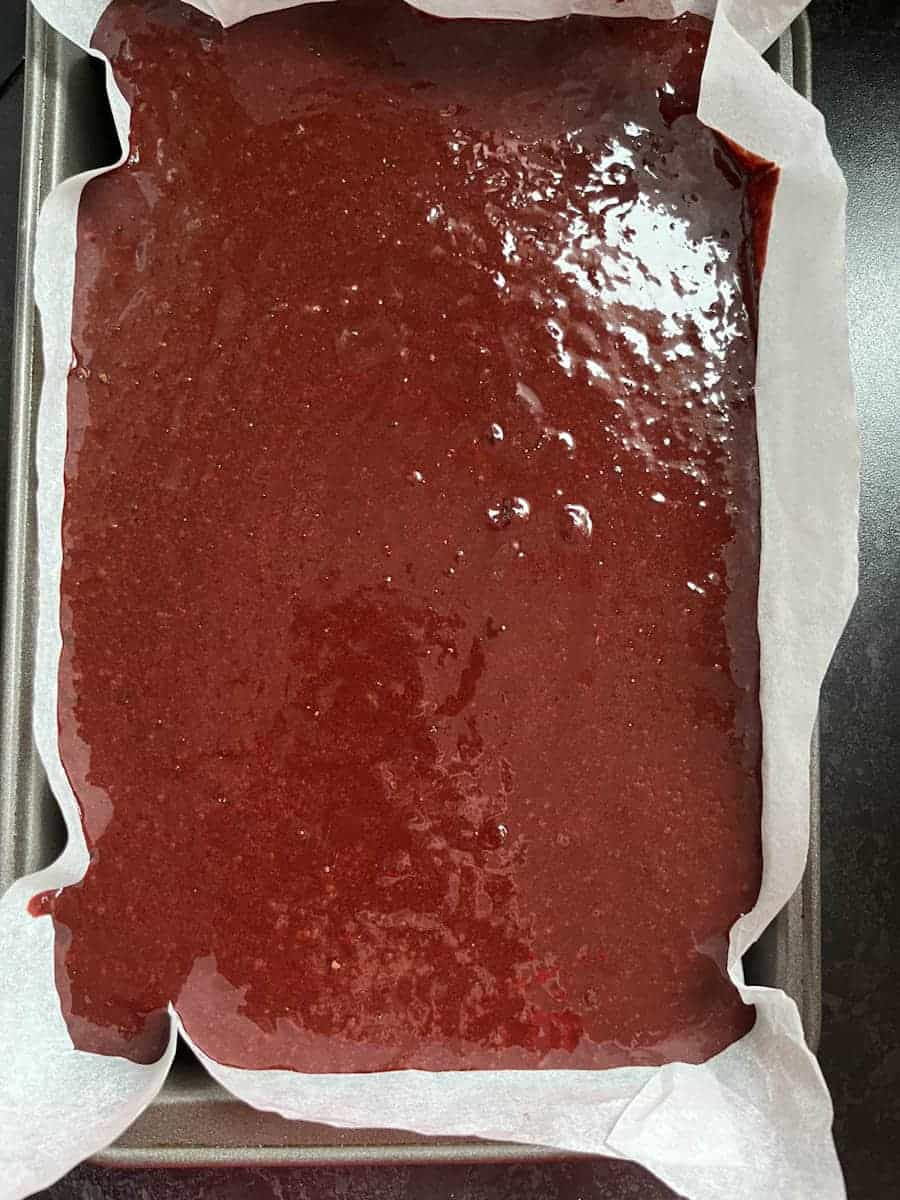 unbaked brownie batter in a lined baking tin.