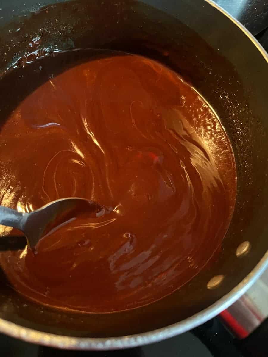 melted chocolate in a saucepan with a silver spoon.