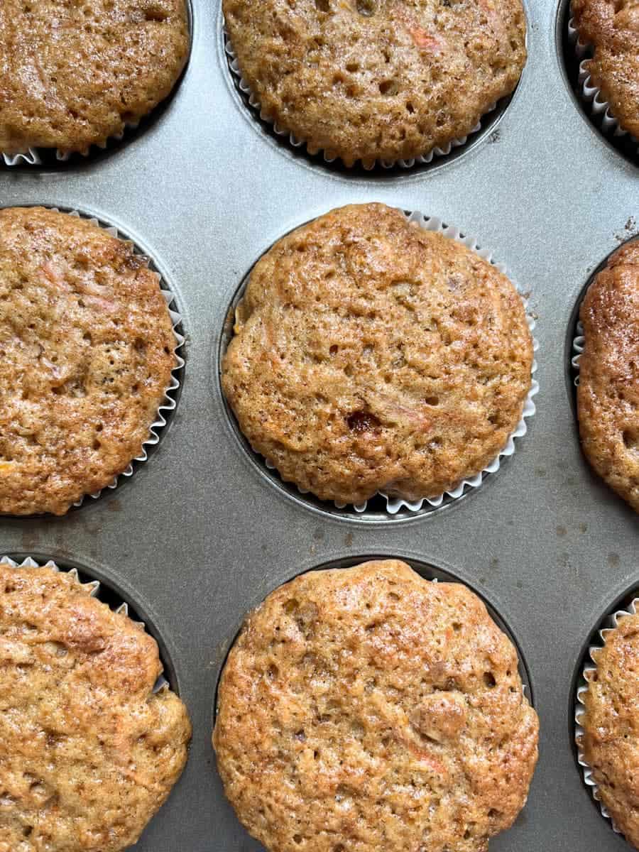 carrot carrot cupcakes in a silver muffin tin.