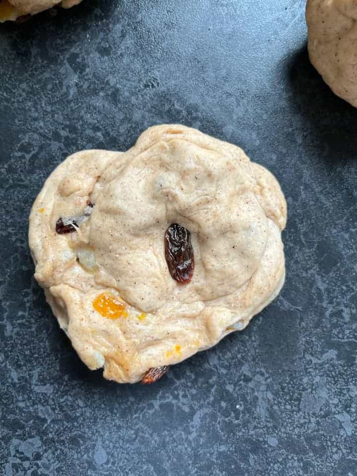 a ball of fruit bread dough on a dark grey work surface.