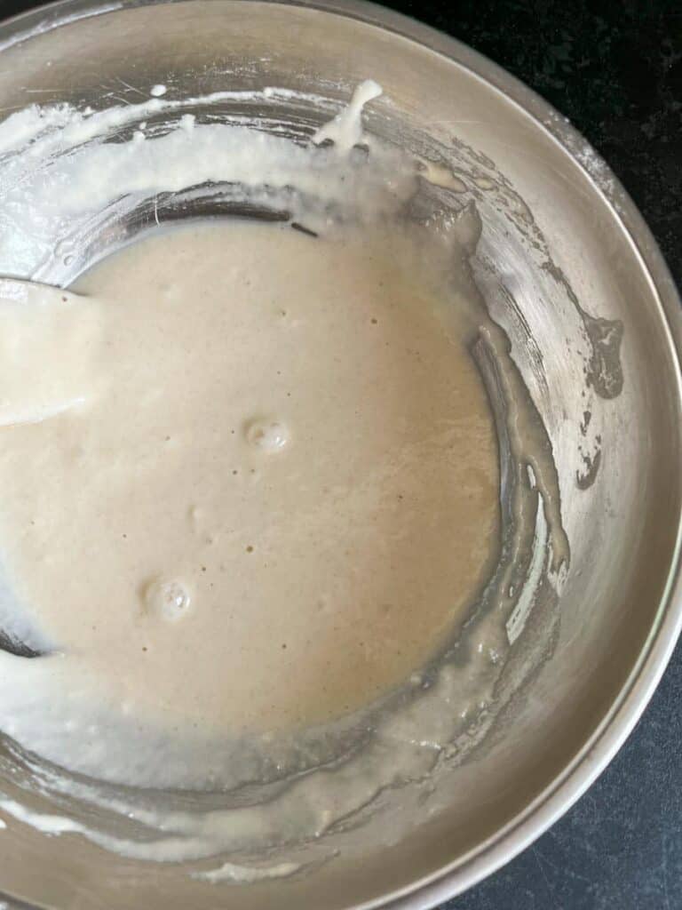 a silver bowl of flour and water mixed together to make a paste.
