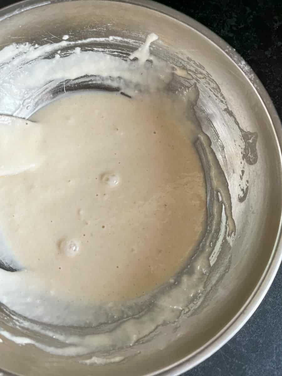 a silver bowl of flour and water mixed together to make a paste.