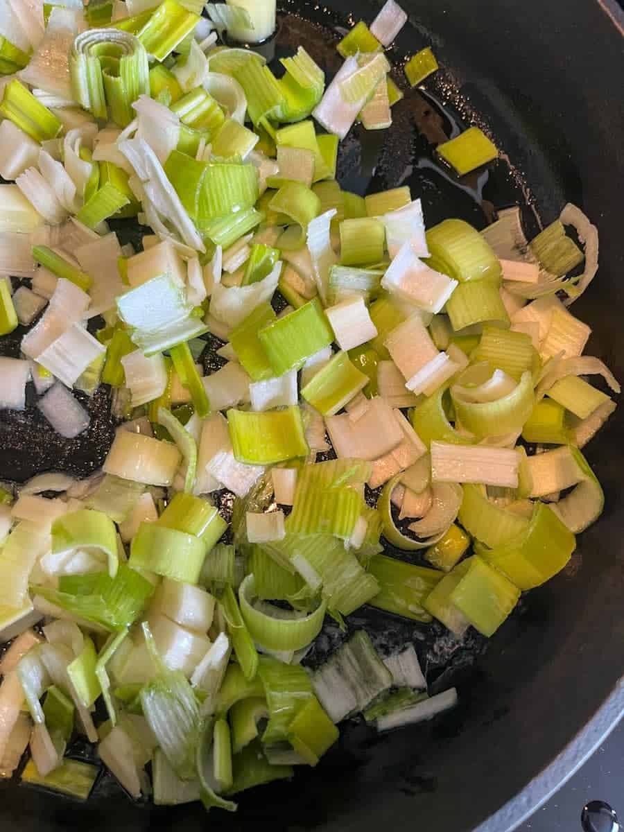 diced leeks in a large frying fan with oil and butter.