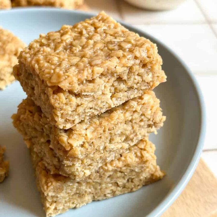 three flapjack bars stacked on top of eachother on a blue plate.