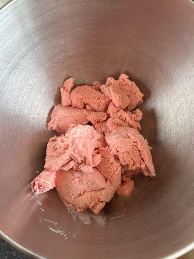 a silver bowl of strawberry ice cream.