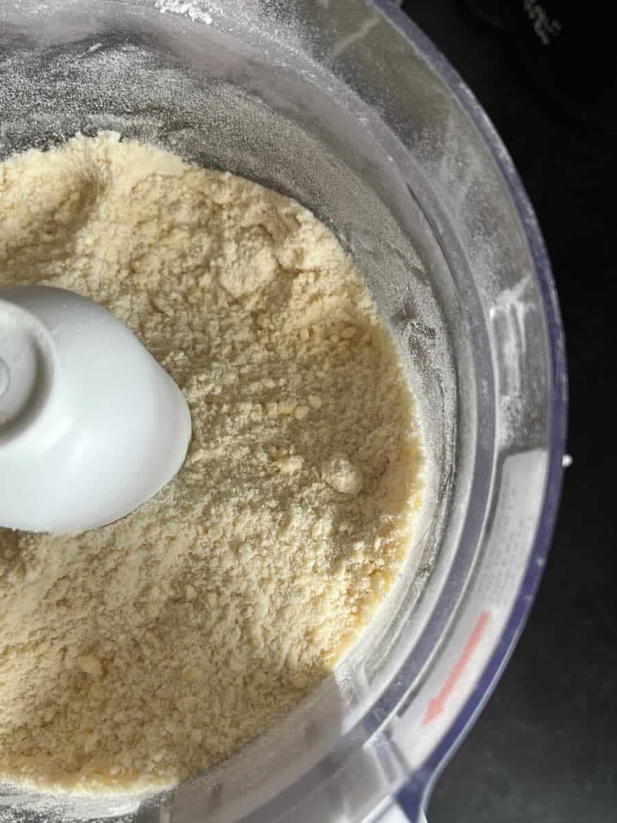 A flour and butter mixture inside a food processor.