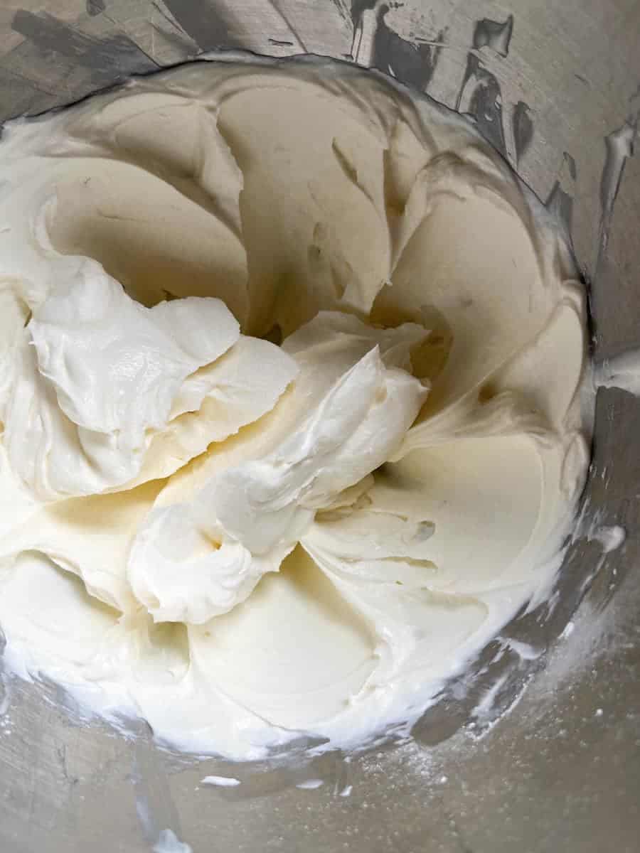 A silver bowl of white no bake cheesecake filling.