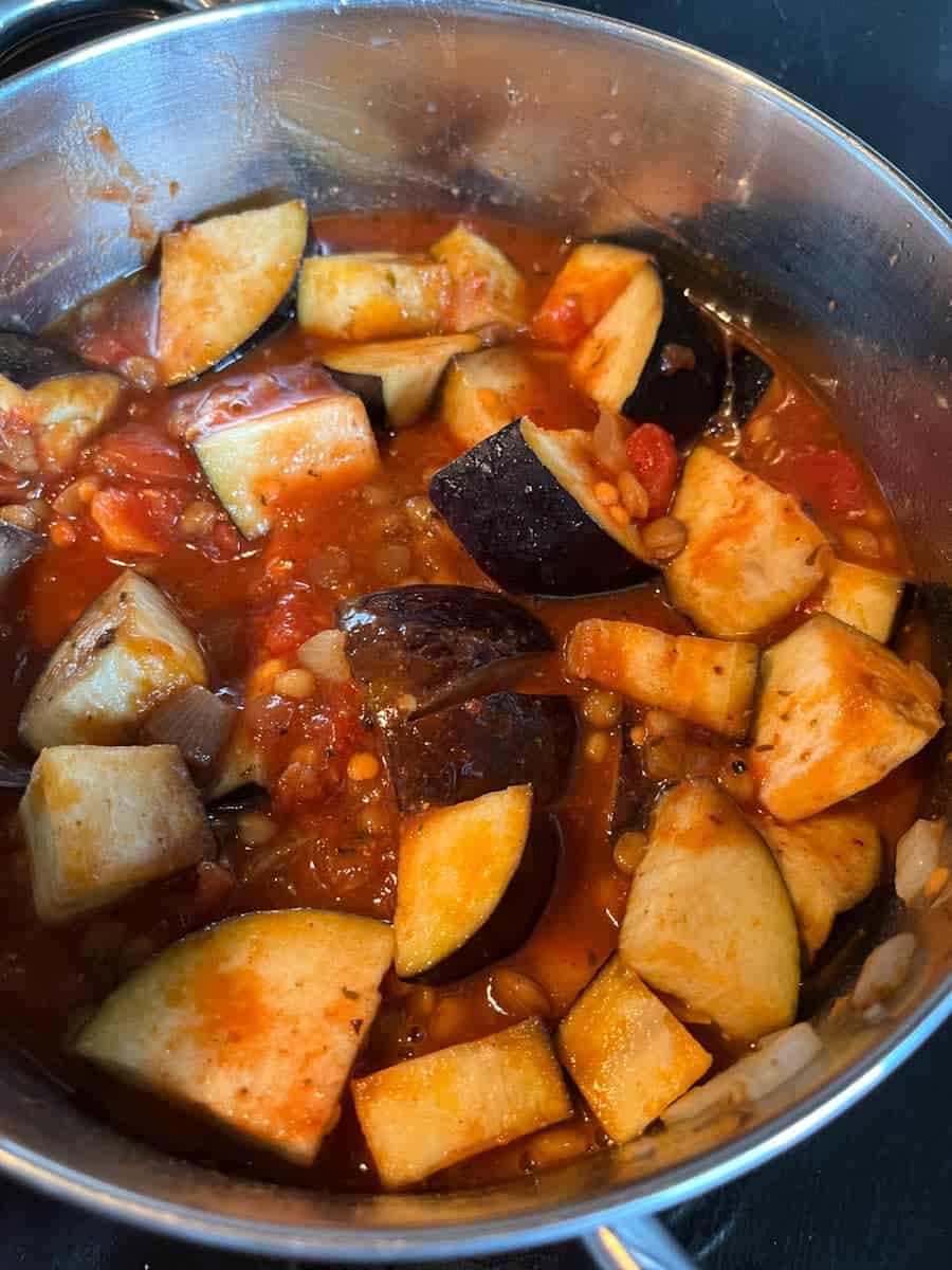 A silver pan of aubergine and lentil chilli.