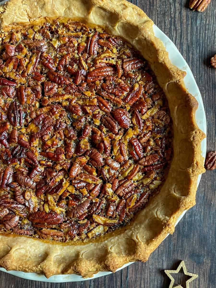 A pecan pie sitting on a wooden table.