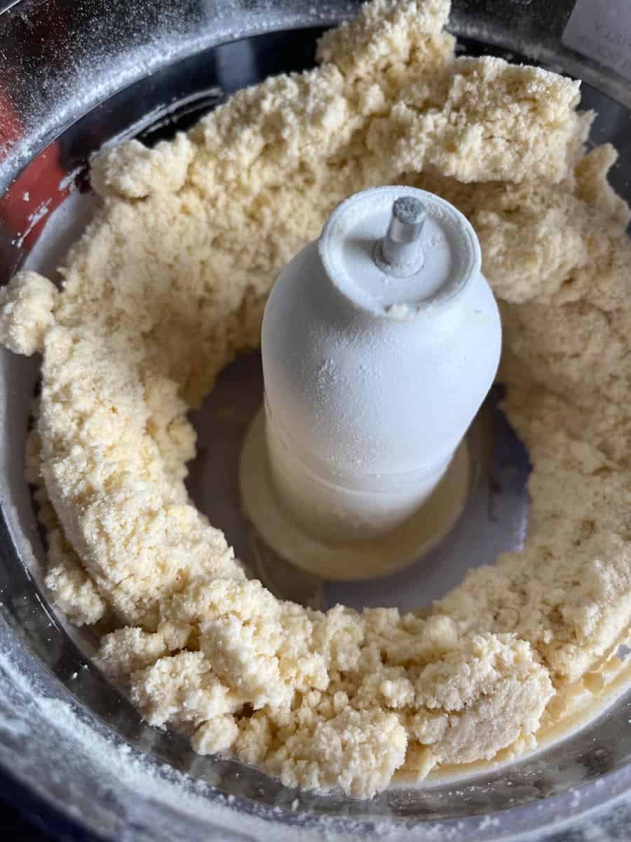 Pie crust dough being made in a food processor.