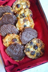 A box of chocolate Florentines lined with red cloth.