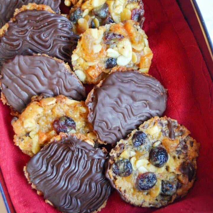 A box of chocolate Florentines lined with red cloth.
