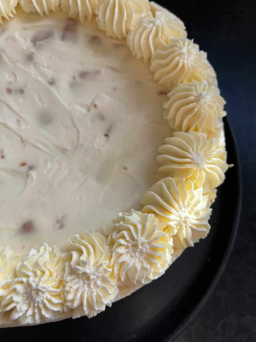 A round no bake cheesecake with whipped cream piped around the edges.