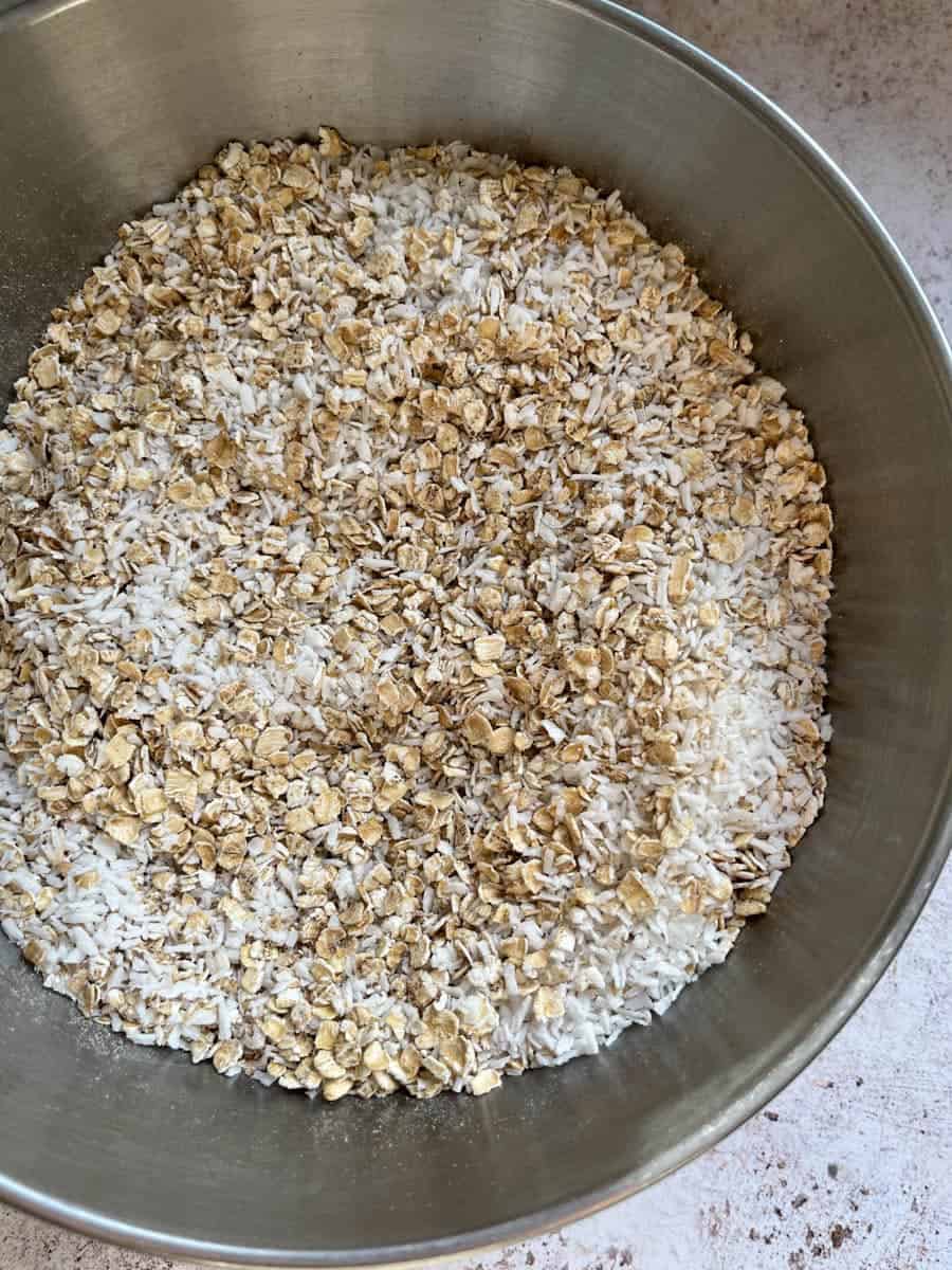 A silver bowl of oats and dessicated coconut.