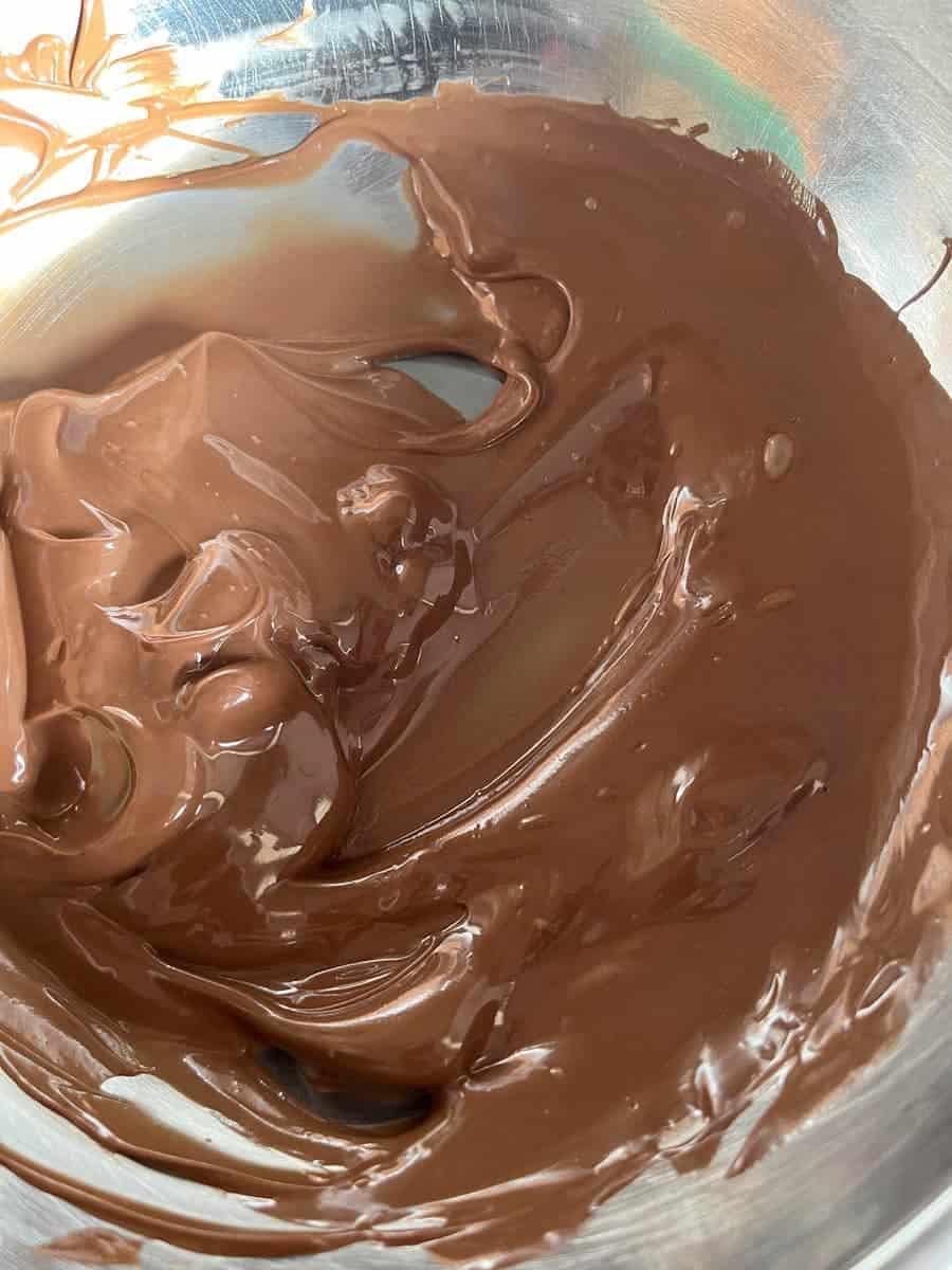 A silver bowl of melted chocolate.