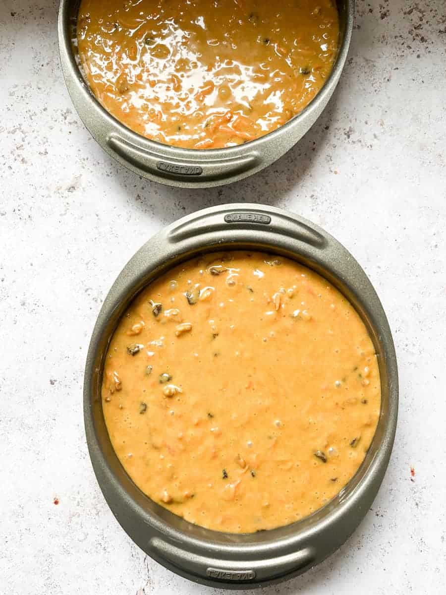 two round cake tins filled with carrot cake batter. 