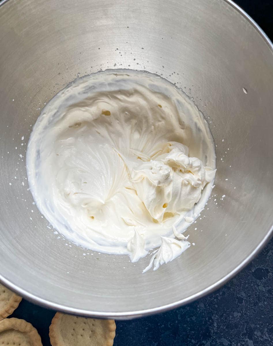 A silver bowl of freshly whipped cream.