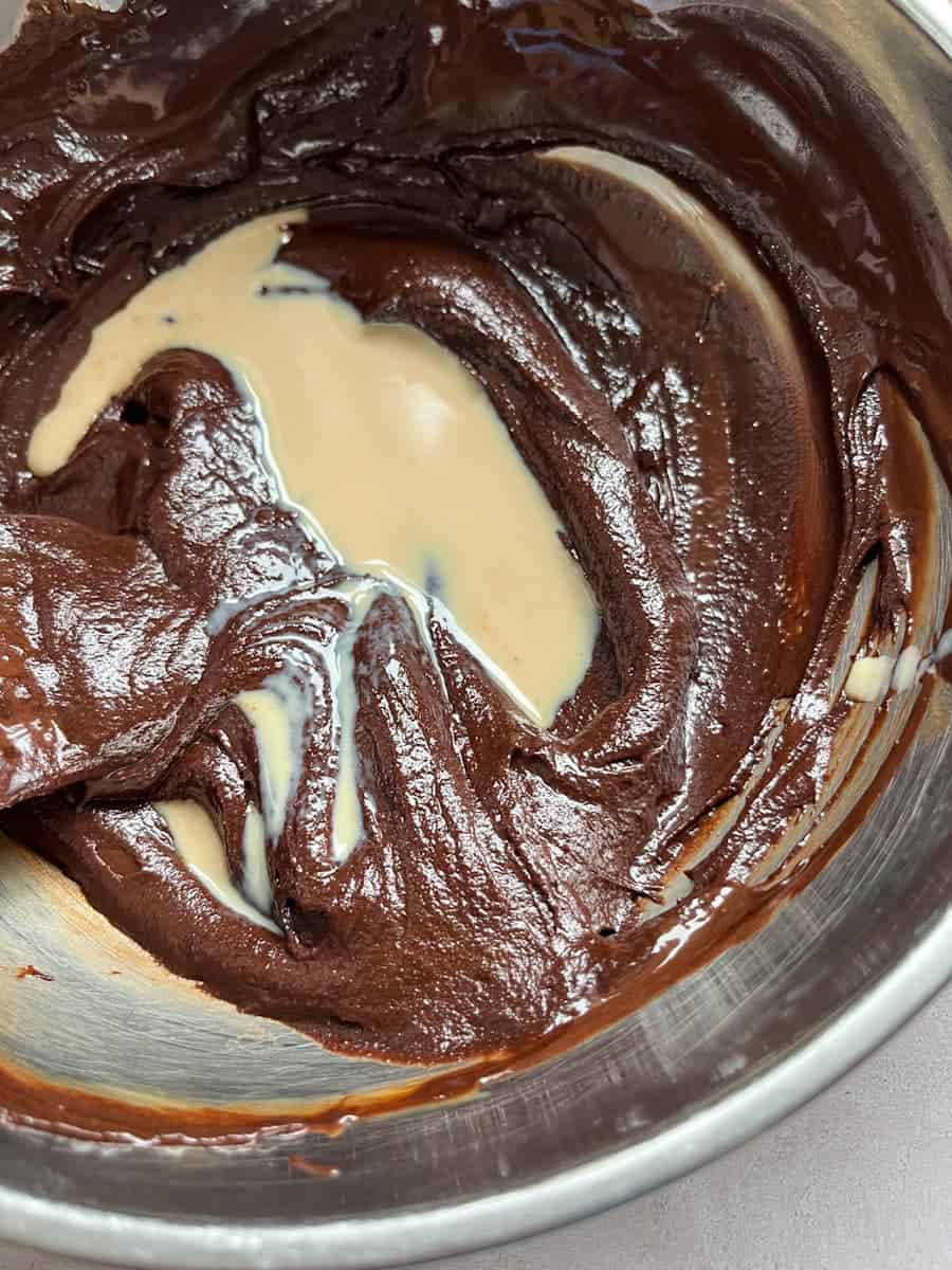 A silver bowl of melted chocolate and Baileys Irish Cream.