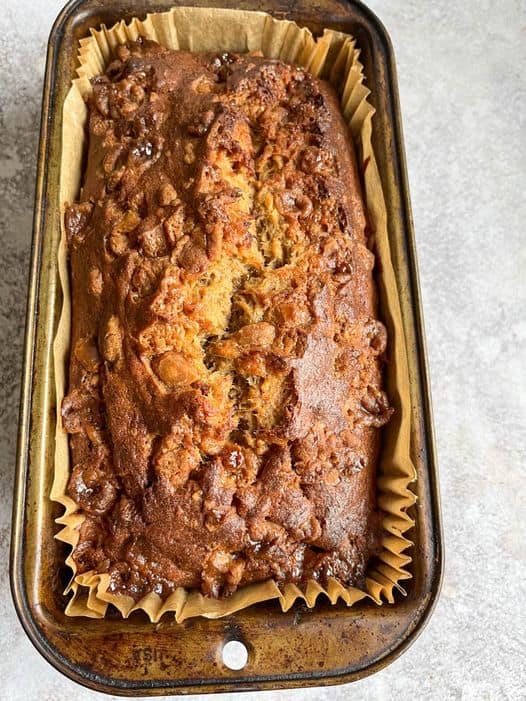 A freshly baked banana loaf topped with fudge pieces.