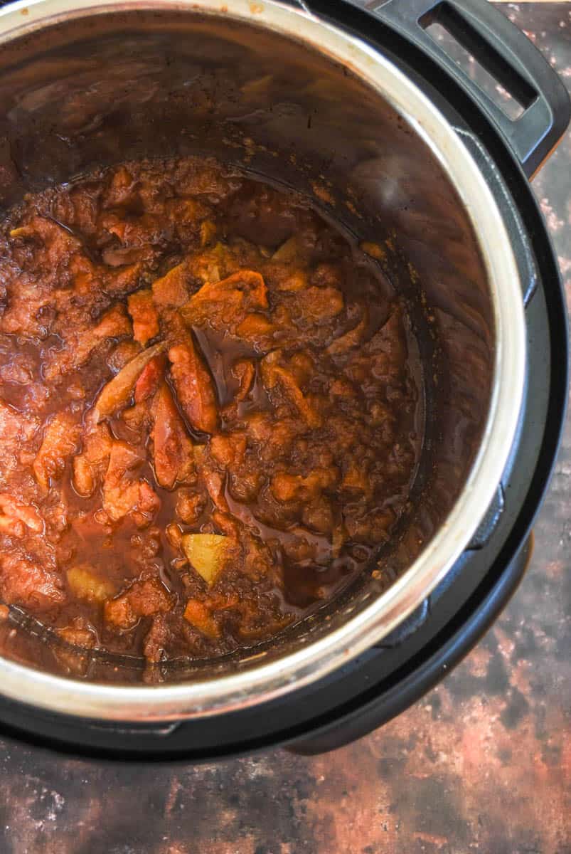 Cooked apples in spices and brown sugar in a pressure cooker.