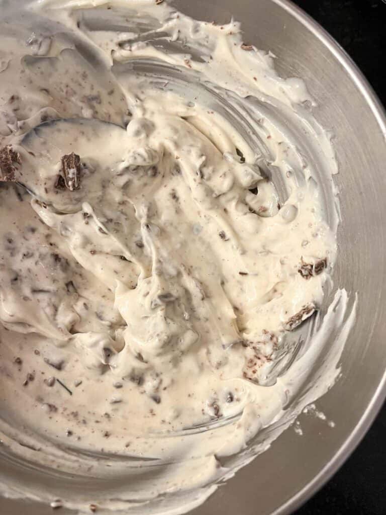 A silver bowl of chocolate cheesecake mixture.