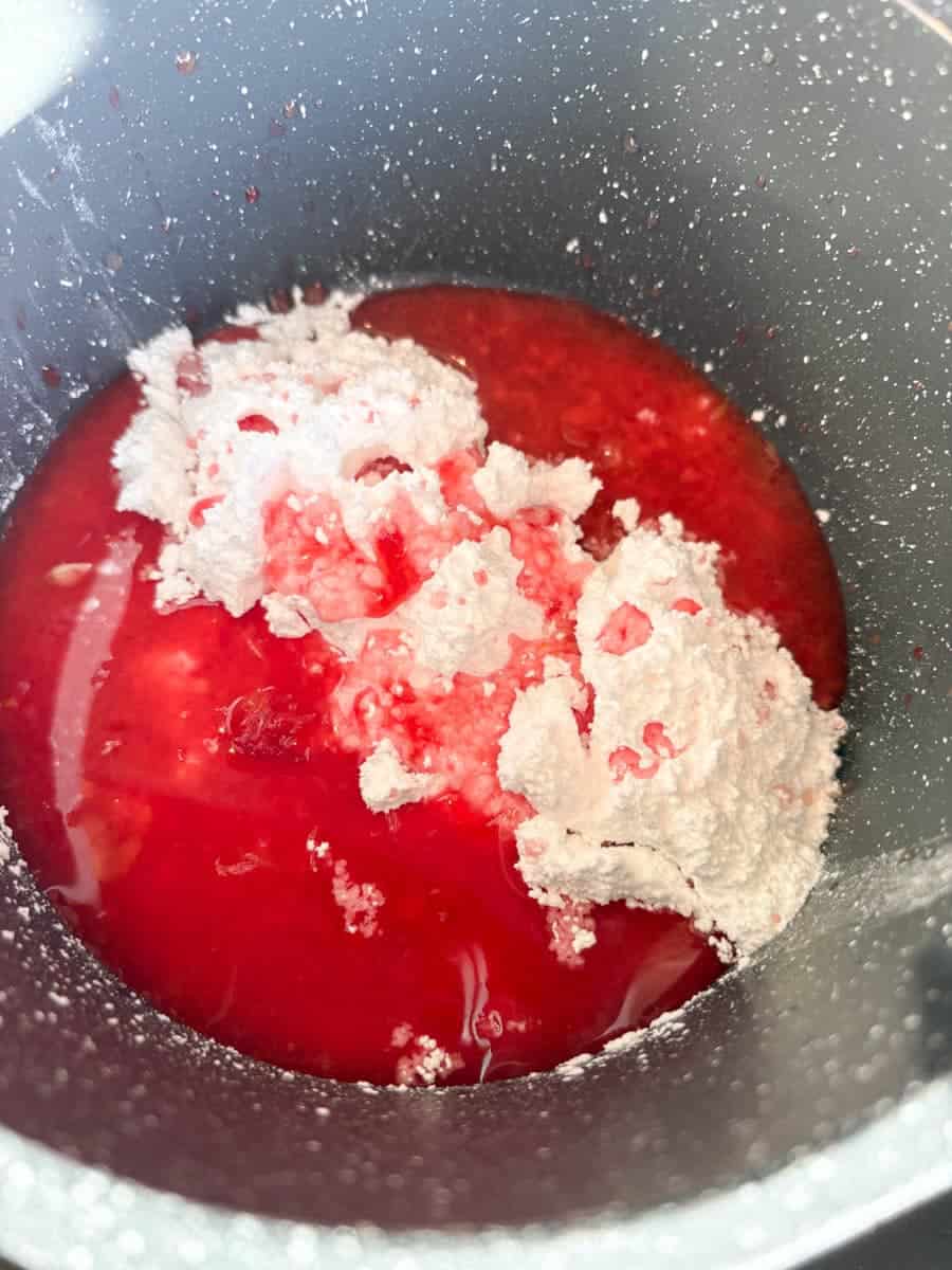 A grey pan of icing sugar and blood orange juice.