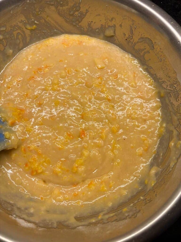 A silver bowl of orange cake batter.
