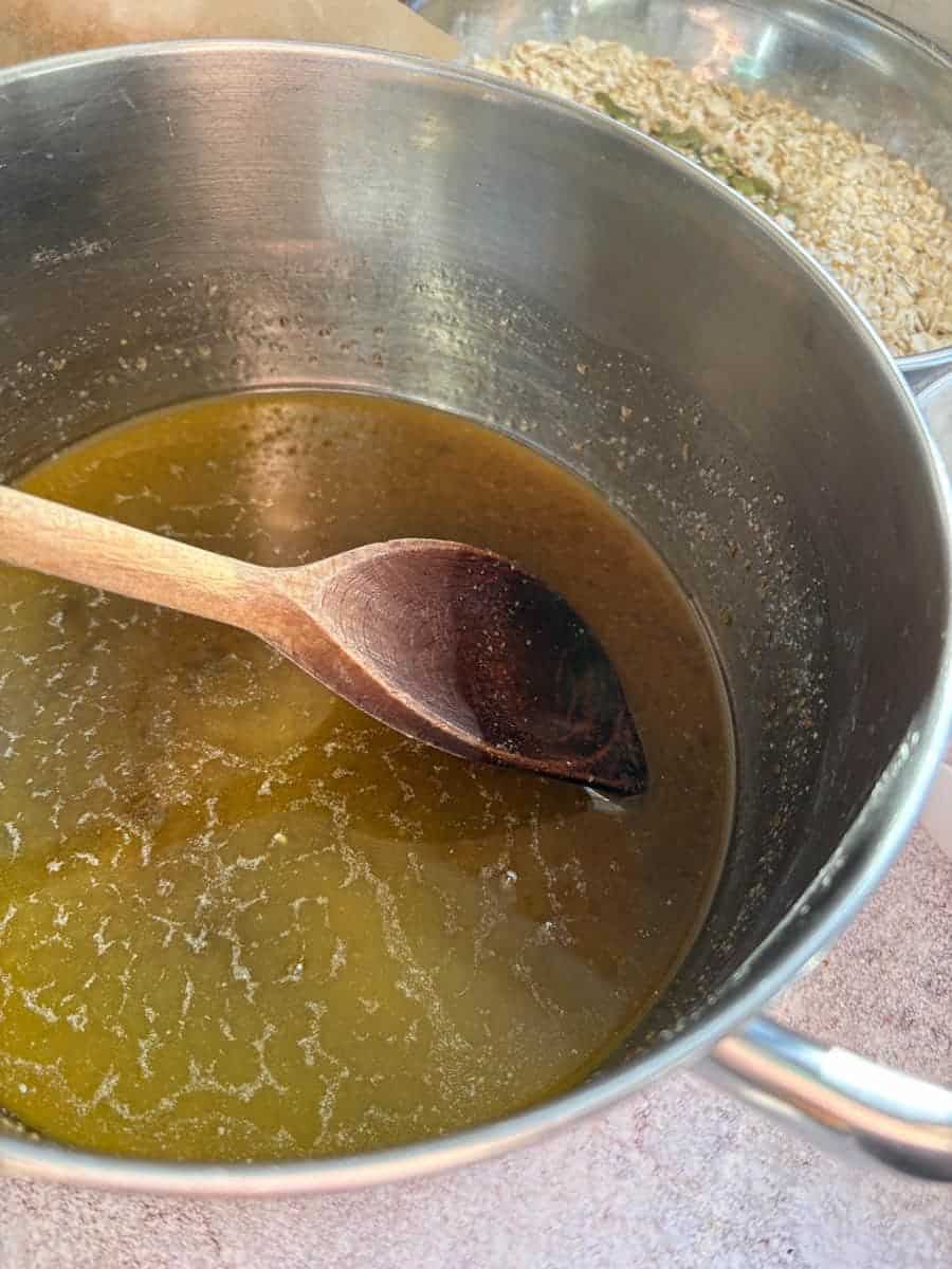 A silver pan of melted butter with a wooden spoon.
